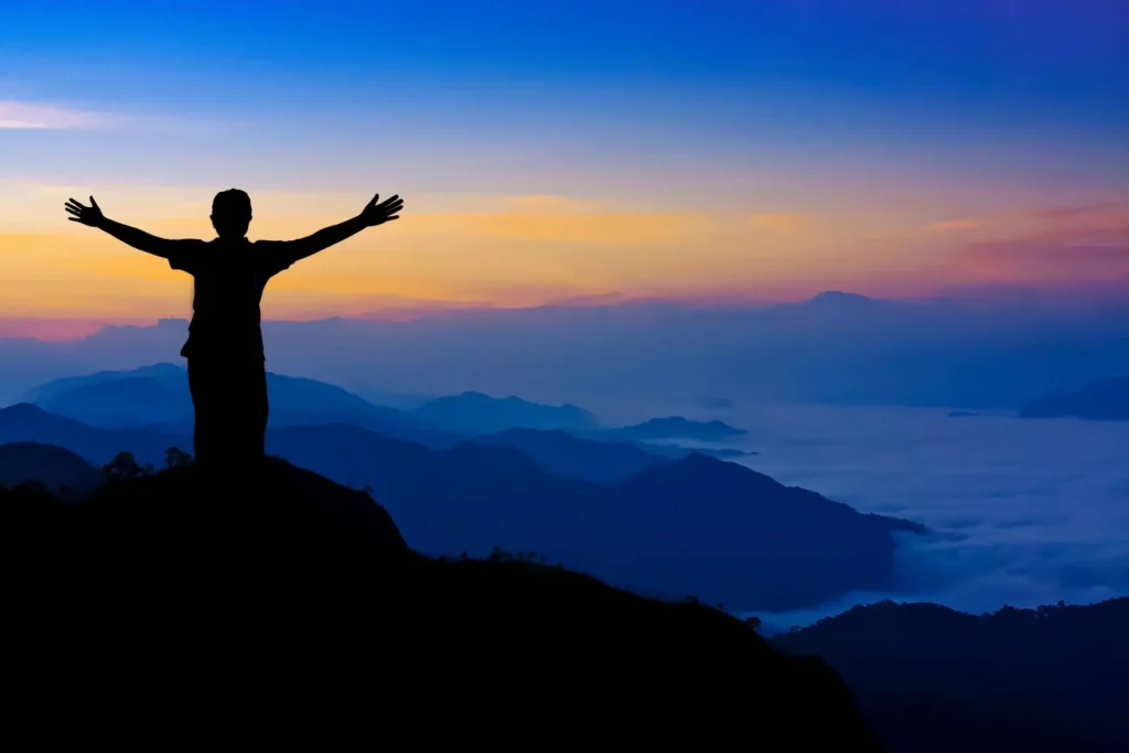 person on a mountain celebrating success