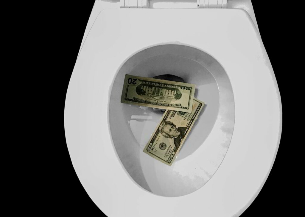 US dollars in a toilet bowl