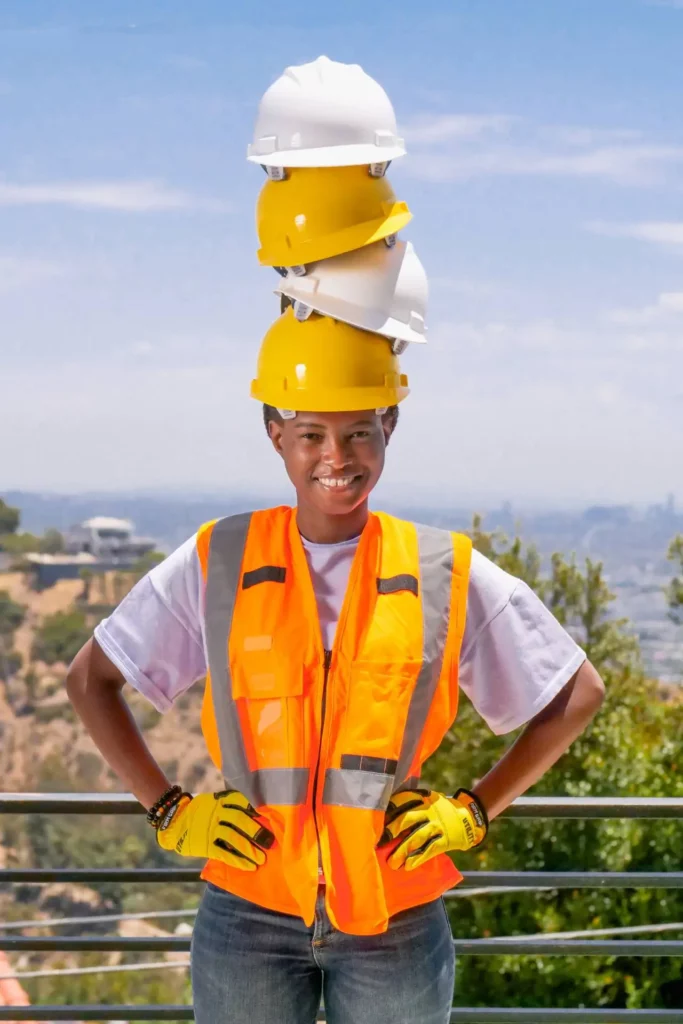 female electrician wearing multiple hardhats