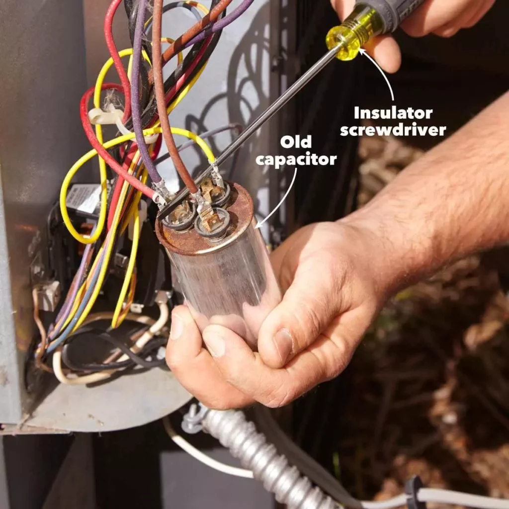 HVAC tech checking a capacitor