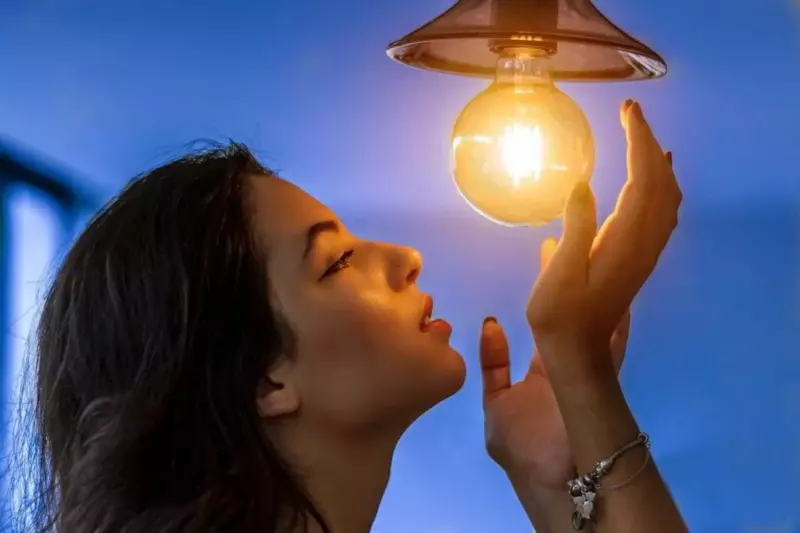 woman staring at a light bulb