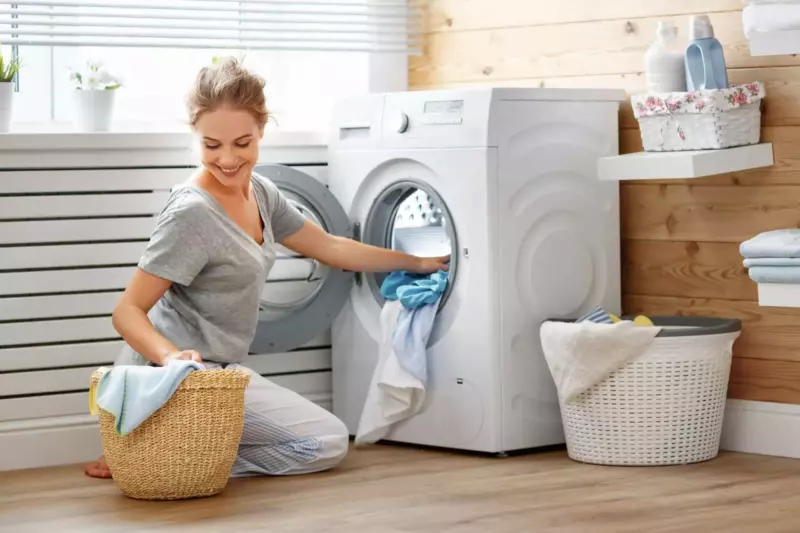 How to Manually Drain a Washing Machine: woman with front loading washing machine