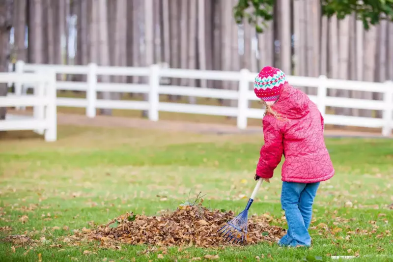 young girl raking leaves