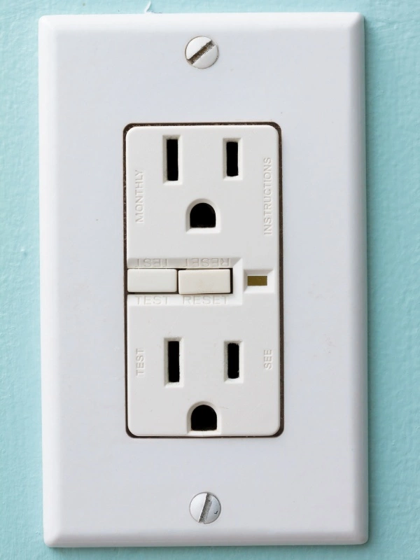 GFCI Electrical Outlet mounted to a blue wall