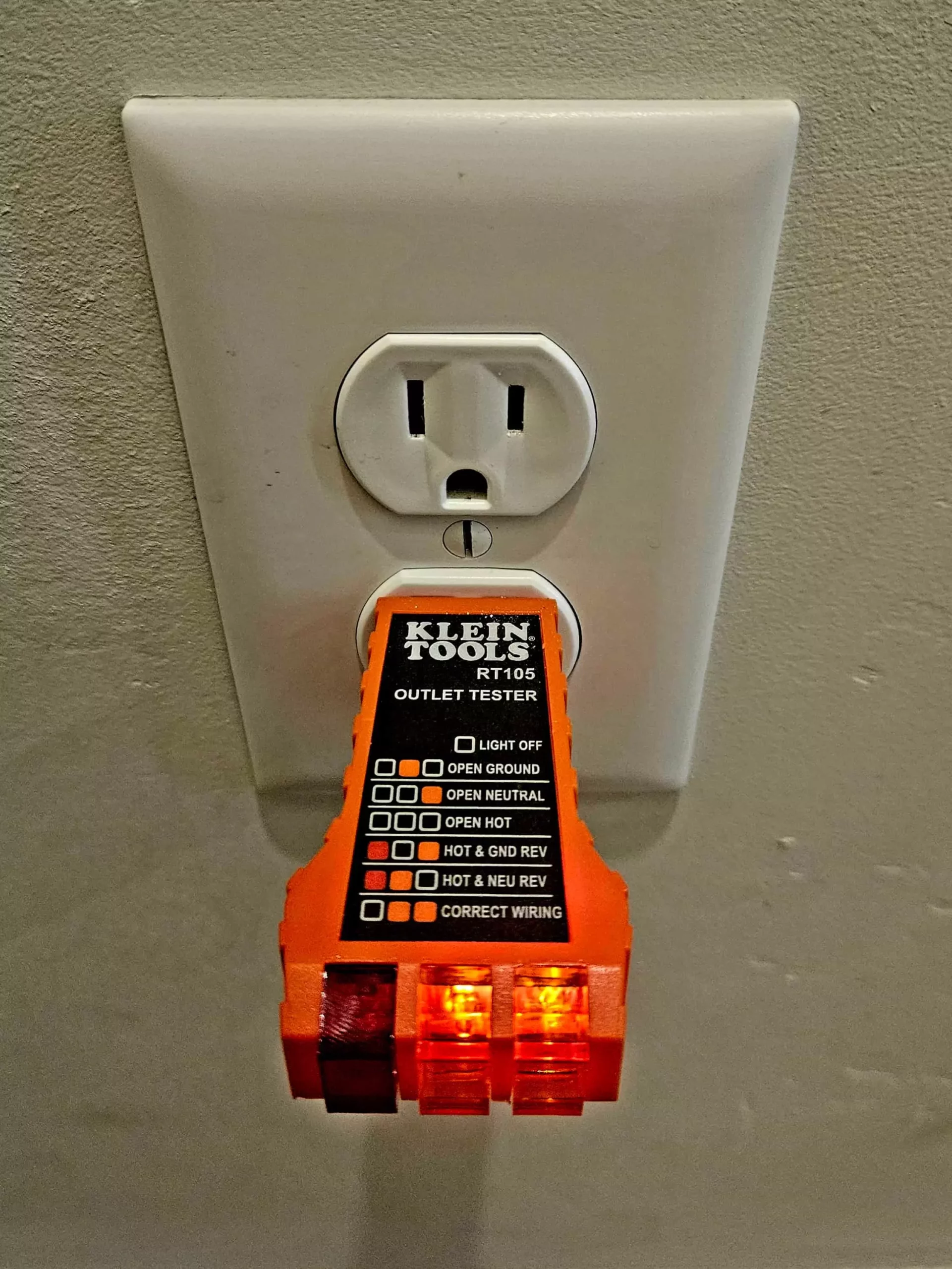 klein electrical outlet tester plugged into an electrical outlet in a residential home 