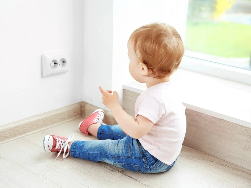 kid about to put finger in electrical outlet